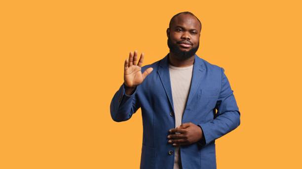 istock Man reluctantly doing salutation hand gesture, saying goodbye, studio background 2151174455