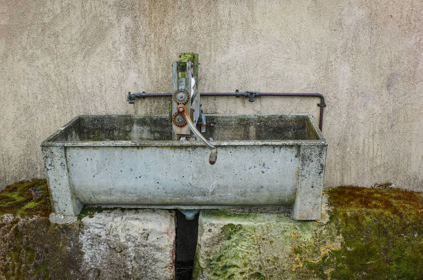 Old concrete water basin with clothes wringer