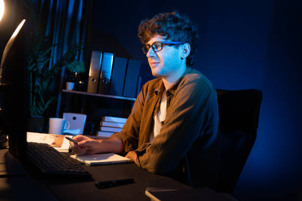 istock Businessman concentrating on pc on project at neon light office. Gusher. 2151175156