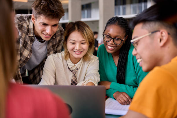 istock Group of diverse multiethnic smiling young students using laptop studying gathering in classroom 2151176313