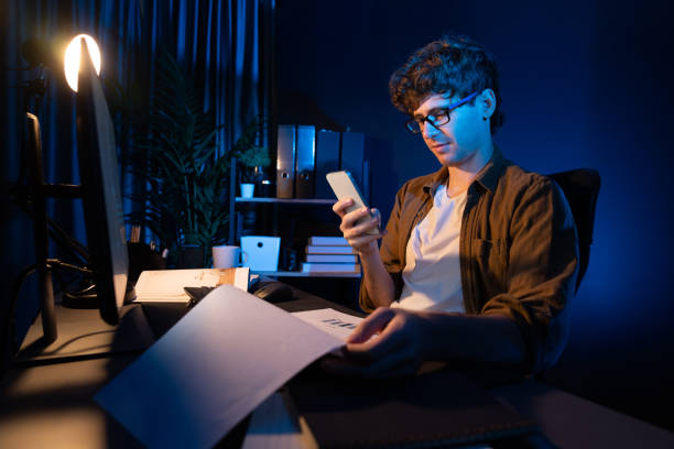 Young businessman looking phone, chatting with customer or coworker. Gusher.