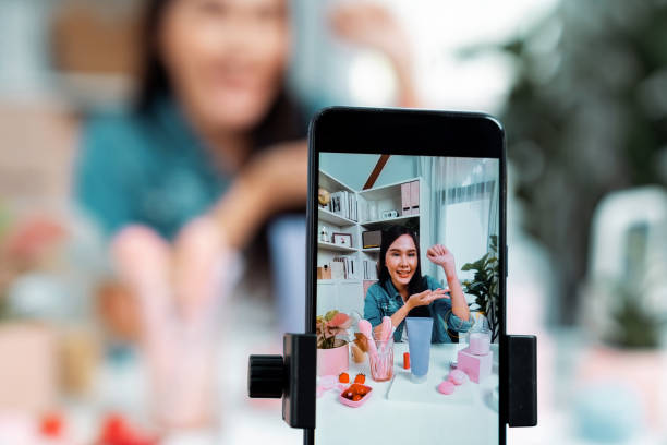 istock Selective focus phone with Asian showing cosmetic makeup lipstick. Stratagem. 2151176968