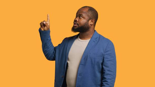 istock Salesman pointing upwards with finger doing recommendation, studio background 2151176972