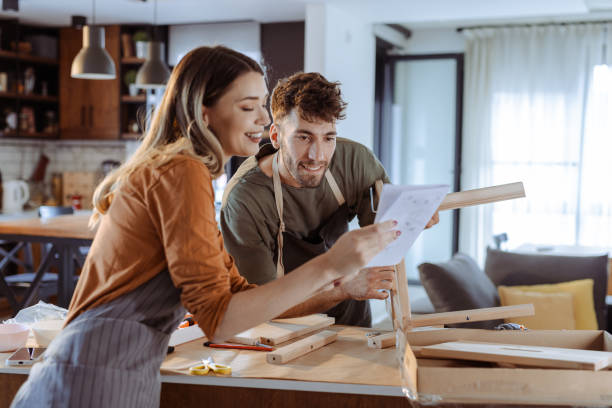 istock Young cheerful couple assembling chair at home 2151177486