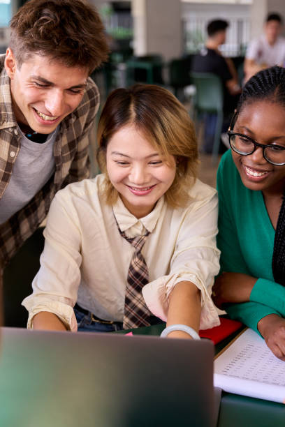 istock Group of diverse multiethnic smiling young students using laptop studying gathering in classroom 2151177637