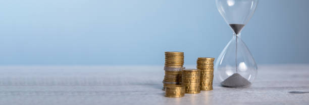 istock Hourglass with coins on gray background 2151178554
