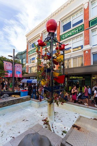 Wellington, New Zealand - March 24, 2024: The Iconic Bucket Fountain in Cuba Street Bedecked with Flowers and Apples for Cuba Dupa Festival 2024, Infusing the Urban Landscape with Colorful Festivity