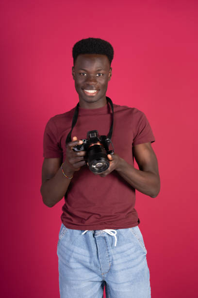 istock A man with a camera is smiling and holding the camera up to his face 2151179963