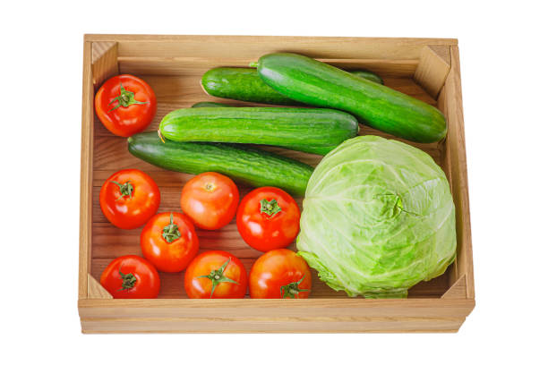 Cucumbers, tomatoes and cabbage in a wooden box isolate