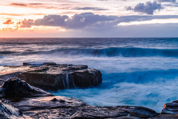 istock Sunrise, sea, waves, clouds and tessellated rock platform 2151181127