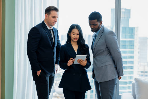 istock Diverse smart businesspeople standing near window with skyscraper. Ornamented.. 2151181755