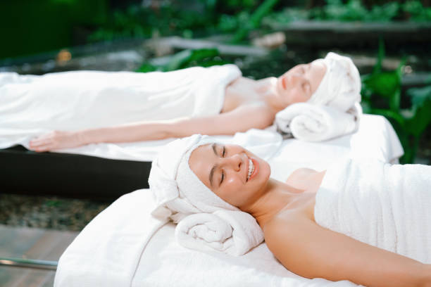 istock Two beautiful young woman lie on bed rounded by peaceful nature. Tranquility. 2151182256