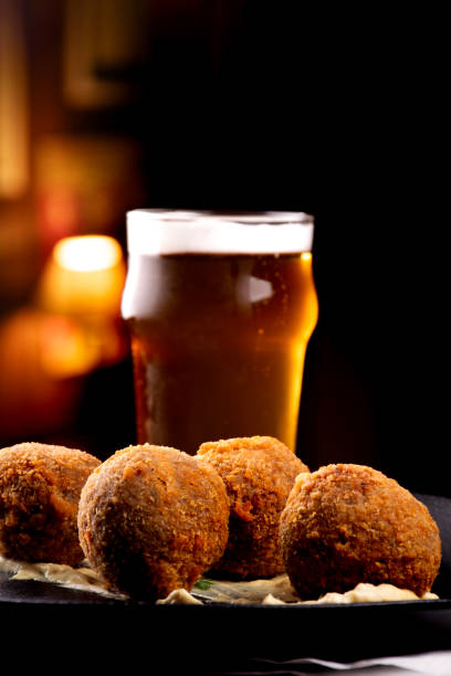 istock fried fish cake appetizer cod salmon half pint of beer blurred and blurred bar background 2151183943