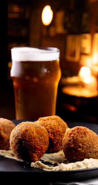 istock fried fish cake appetizer cod salmon half pint of beer blurred and blurred pub background 2151183946