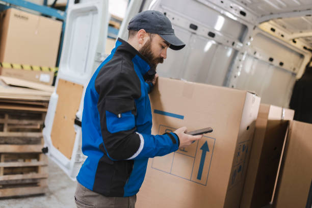 istock The delivery man uses a mobile phone while preparing the package for delivery to the customer 2151185418