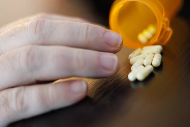 istock ADHD Pills and medication bottle on counter as man reaches for them. 2151186367