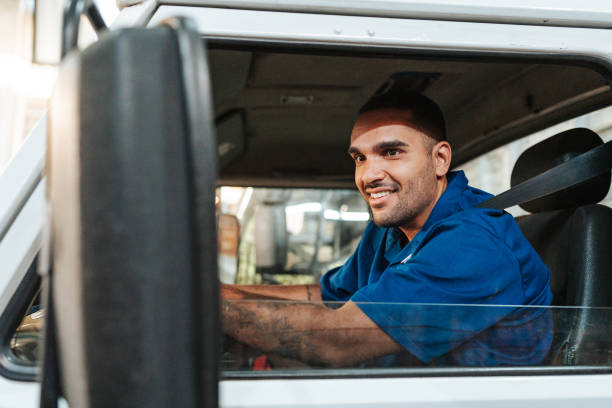 istock Truck driver looking in side mirror 2151192331