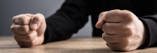 istock man fists on a wooden table 2151196590