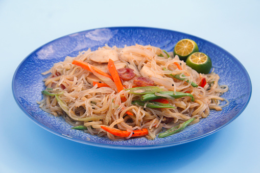 Photo of freshly cooked Filipino food called Pancit Bihon or stir fried glass noodles with vegetables.