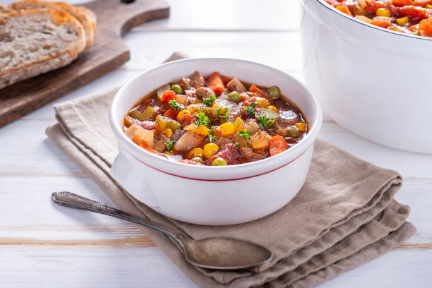 Vegetable Soup Bowl of Homemade Vegetable Soup with Peas, Corn, Carrot, Celery, Tomato, Onion and Thyme stew stock pictures, royalty-free photos & images