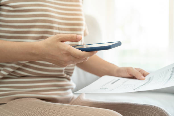 istock woman use phone scan barcode or QR codes to pay credit card bill after receiving document invoice. payment, receive, paying electricity, digital payments, technology, scanning, financial transactions 2151202787