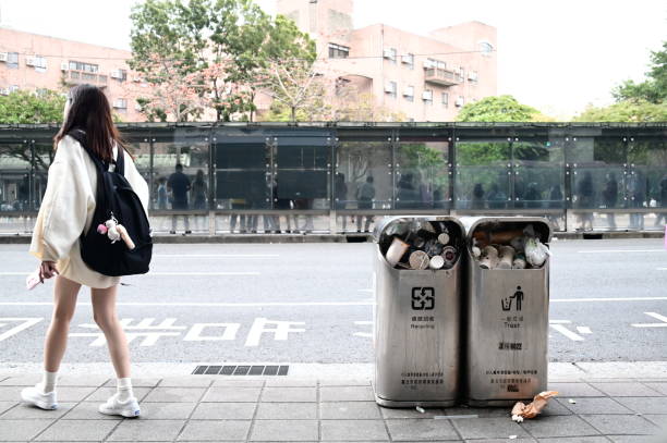 Taiwan - Mar 24, 2024: Overflowing trash cans and recycling bins near a bus stop adjacent to Gongguan business district close to National Taiwan University, captured in a close-up shot.