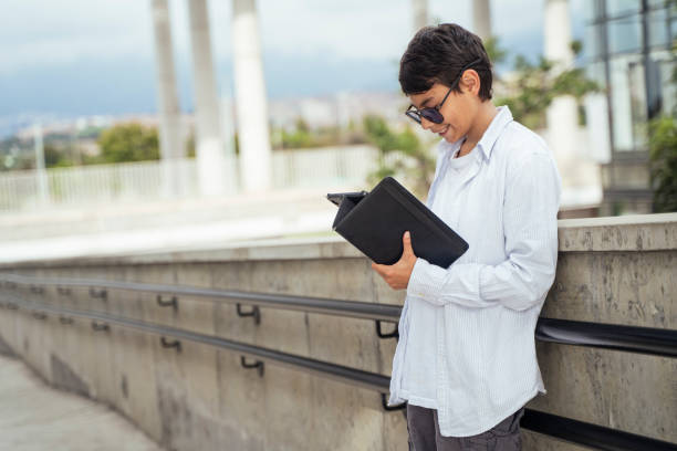 istock Teenage boy watching videos from his digital tablet 2151212799
