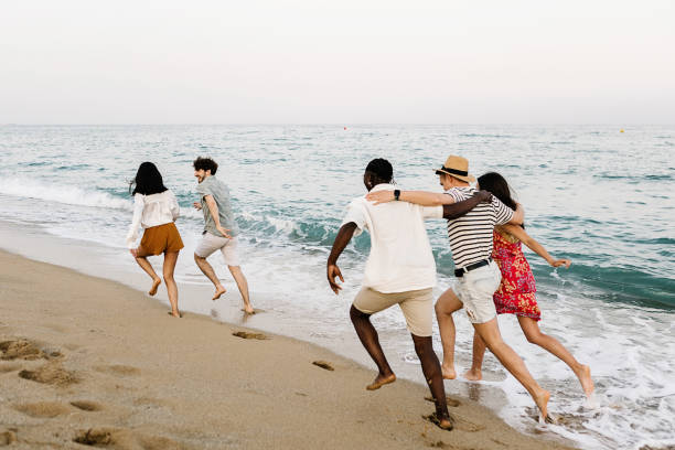 istock Young group of people running on the beach 2151216203