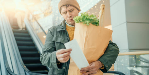 istock Man Checking Grocery List in Shopping Mall 2151216449