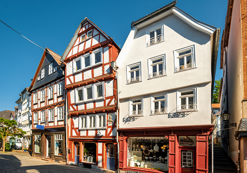 alley in old town Marburg with colorful half-timbered  houses under blue summer sky