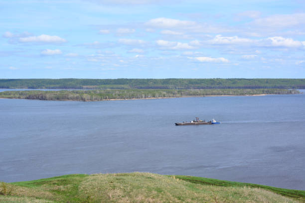 a barge is floating on the water and the sky with clouds