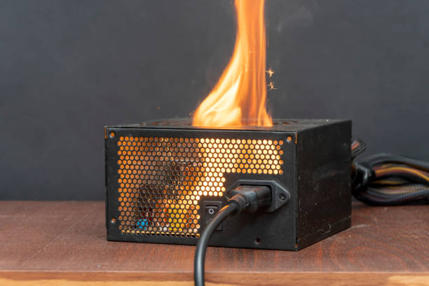 istock Ignition of the computer power supply, short circuit, close-up, selective focus. A fire in the apartment from household electrical appliances. 2151228234