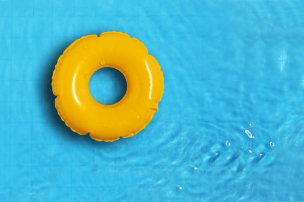 istock Yellow ring floating in refreshing blue swimming pool. 2151229432