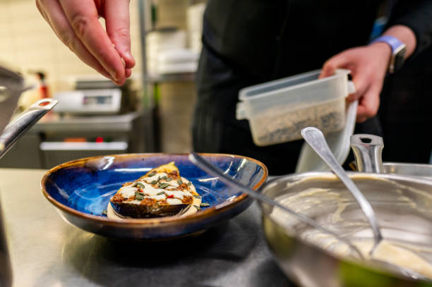 istock skilled chef meticulously garnishes a gourmet dish in a professional kitchen. The focus is on the hands, which are adding the final touches to the beautifully presented food. 2151233068
