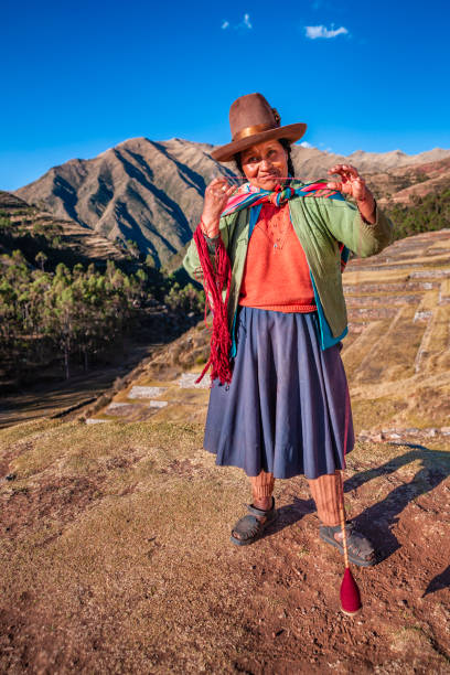 istock Peruvian woman spinning wool by hand, Sacred Valley, Peru 2151238057