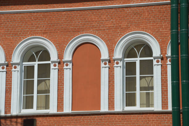 istock Element of the facade of a red brick building with white arched windows. 2151239578