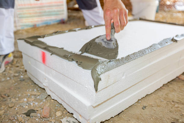 istock Worker applies the glue to thermal isolation material, styrofoam with spatula 2151240942