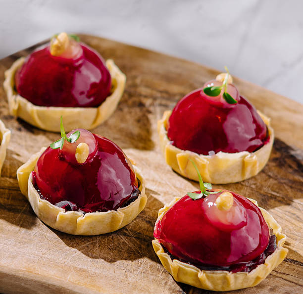 istock Elegant raspberry tarts on wooden board 2151241418
