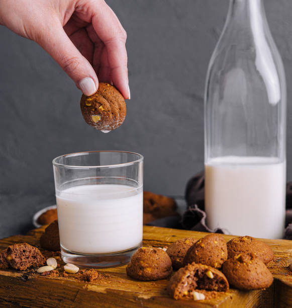 istock Hand dipping cookie in milk glass 2151242334