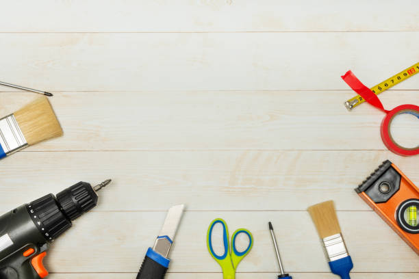 Set of tools for a builder or electrician on a wooden background. Flat layout. There is space for text.