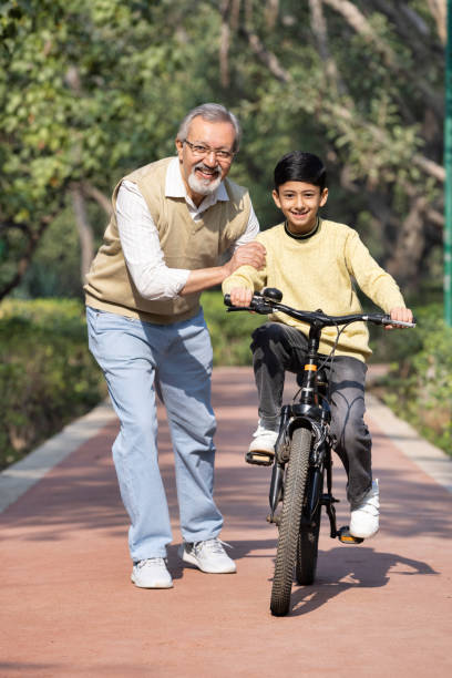 istock Boy learning bicycle with assistance of grandfather at park 2151244228