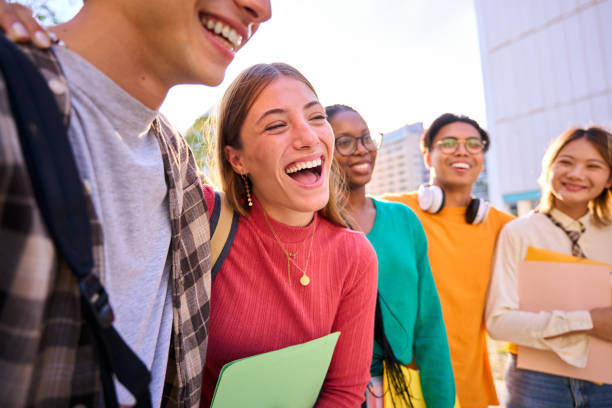 istock Laughing Caucasian female student with multiracial group of classmates posing hugging 2151244340