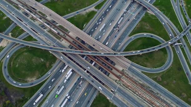 istock Aerial urban spectacle, metro train cuts through traffic-heavy highways, commuters in constant motion. Aerial view where metro train intersects with vehicular veins, showcasing urban flow diversity. 2151244496