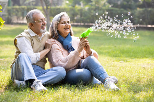 istock Senior couple having fun blowing bubbles at park 2151245833