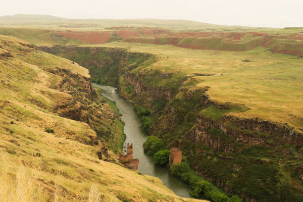 The destroyed, ruined bridge that was built over the Akhurian River down in the canyon, gorge that now forms the border between Turkey and Armenia at the ancient site of Ani, an abandoned ruined armenian city, close to Kars, Turkey 2022 el puente destruido y en ruinas que se construyó sobre el río akhurian en el cañón, desfiladero que ahora forma la frontera entre turquía y armenia en el antiguo sitio de ani, una ciudad armenia en ruinas abandonada, cerca de kars, turquía