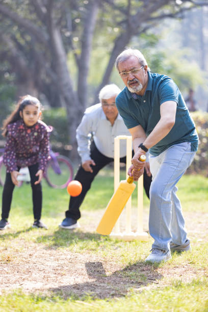 istock Family playing cricket in park 2151246567