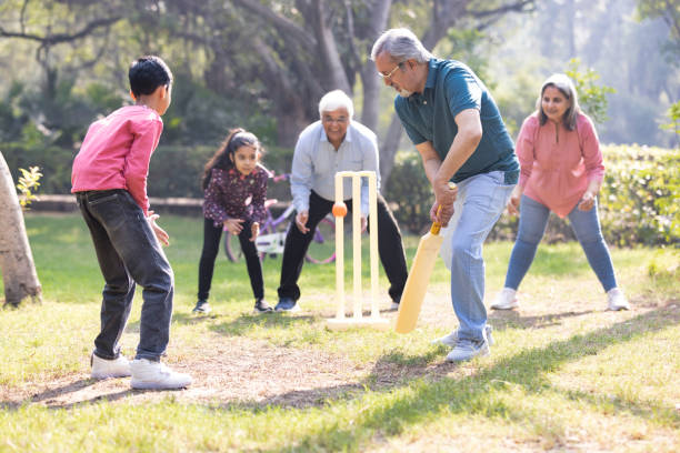 istock Family playing cricket in park 2151246627