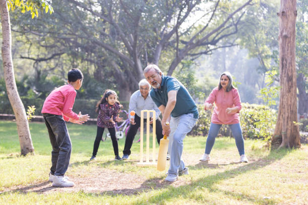 istock Family playing cricket in park 2151246628