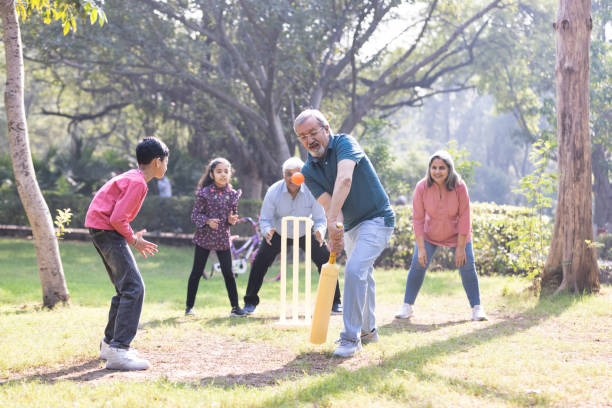 istock Family playing cricket in park 2151246631