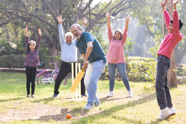 istock Family playing cricket in park 2151246701